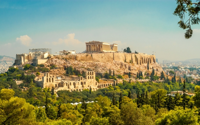 The ancient Parthenon temple on the Acropolis of Athens, Greece, showcasing its iconic Doric columns and classical architecture, standing grandly under a clear blue sky.